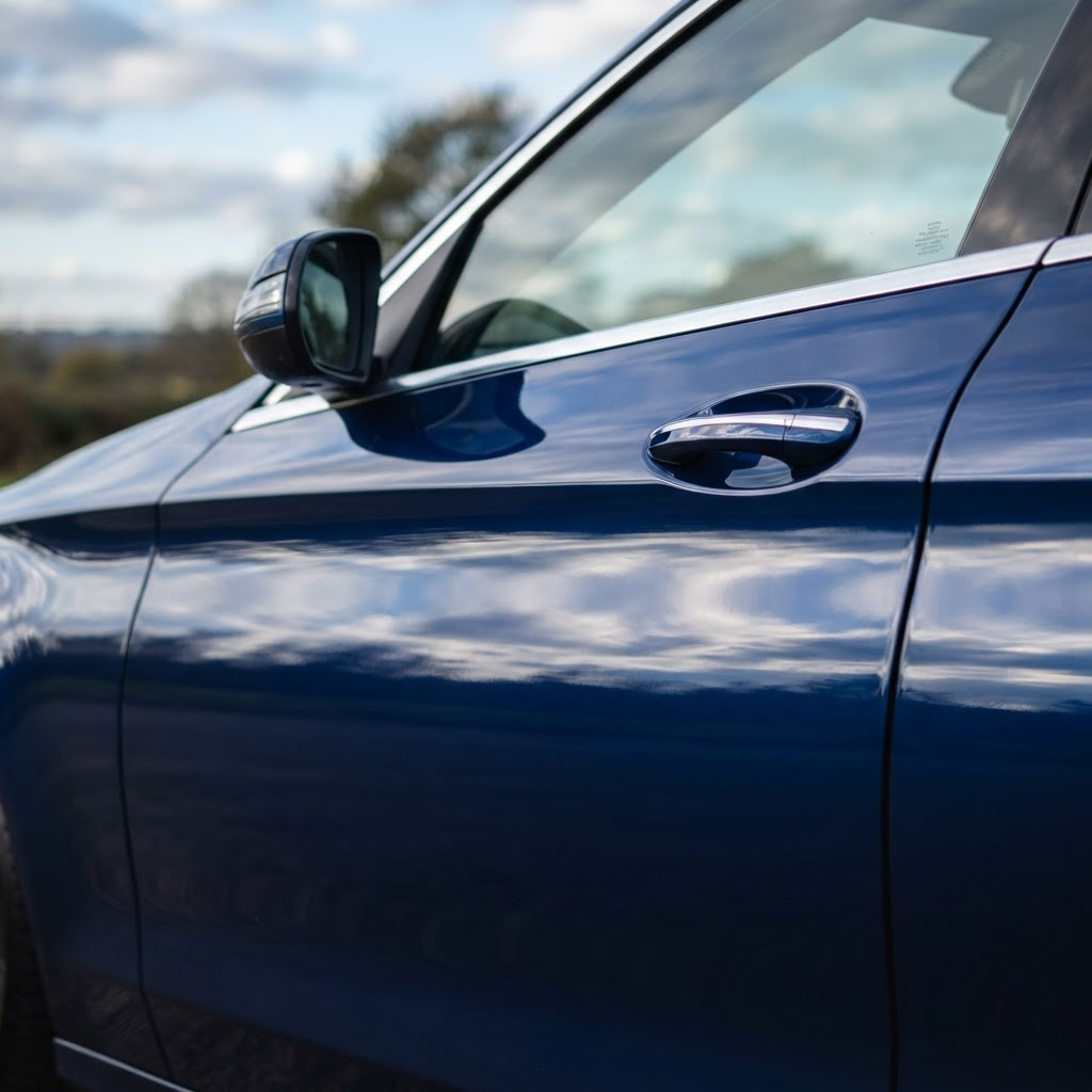 Car door panel with a mirror-like glossy paint finish reflecting light